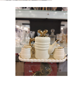 Luxury porcelain tea set with golden touches, consisting of one teapot, four cups, and one rectangular tray
