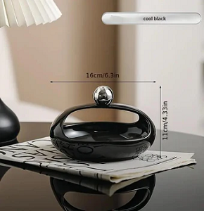 Bonbonniere, glossy black, oval shape with a hollow modern design, ideal for serving sweets.

