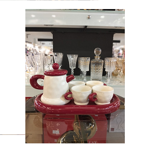 A tea set consisting of a porcelain teapot, four cups, and one serving tray
