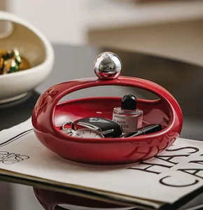 Bonbonniere, glossy red, oval shape with a hollow modern design, ideal for serving sweets.
