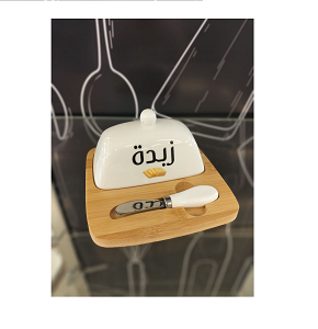 A butter box made up of a rectangular wooden base with slots for the lid and the knife, a white porcelain lid with handle, and a knife with a porcelain handle and sharp blade. An elegant design combin