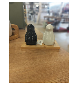 Set of 2-piece porcelain salt and pepper shakers shaped like white and black penguins with elegant bamboo wooden base 
