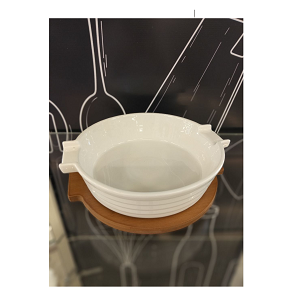 Glossy white round porcelain casserole 30 cm with horizontal patterns and integrated handles with elegant dark wooden base perfect for stylish serving from oven to table 
