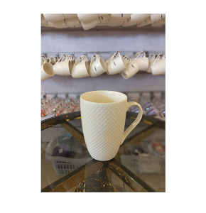 Elegant porcelain mug in matte creamy color with comfortable handle 
