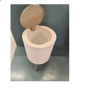 Elegant modern Scandinavian trash bin made of white plastic with light wooden legs and wooden lid with push button for easy opening combining practicality and beauty 
