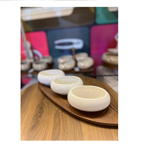  Serving Set 3-Piece  of white porcelain bowls with an oval design, presented on a natural wooden base shaped like a leaf.