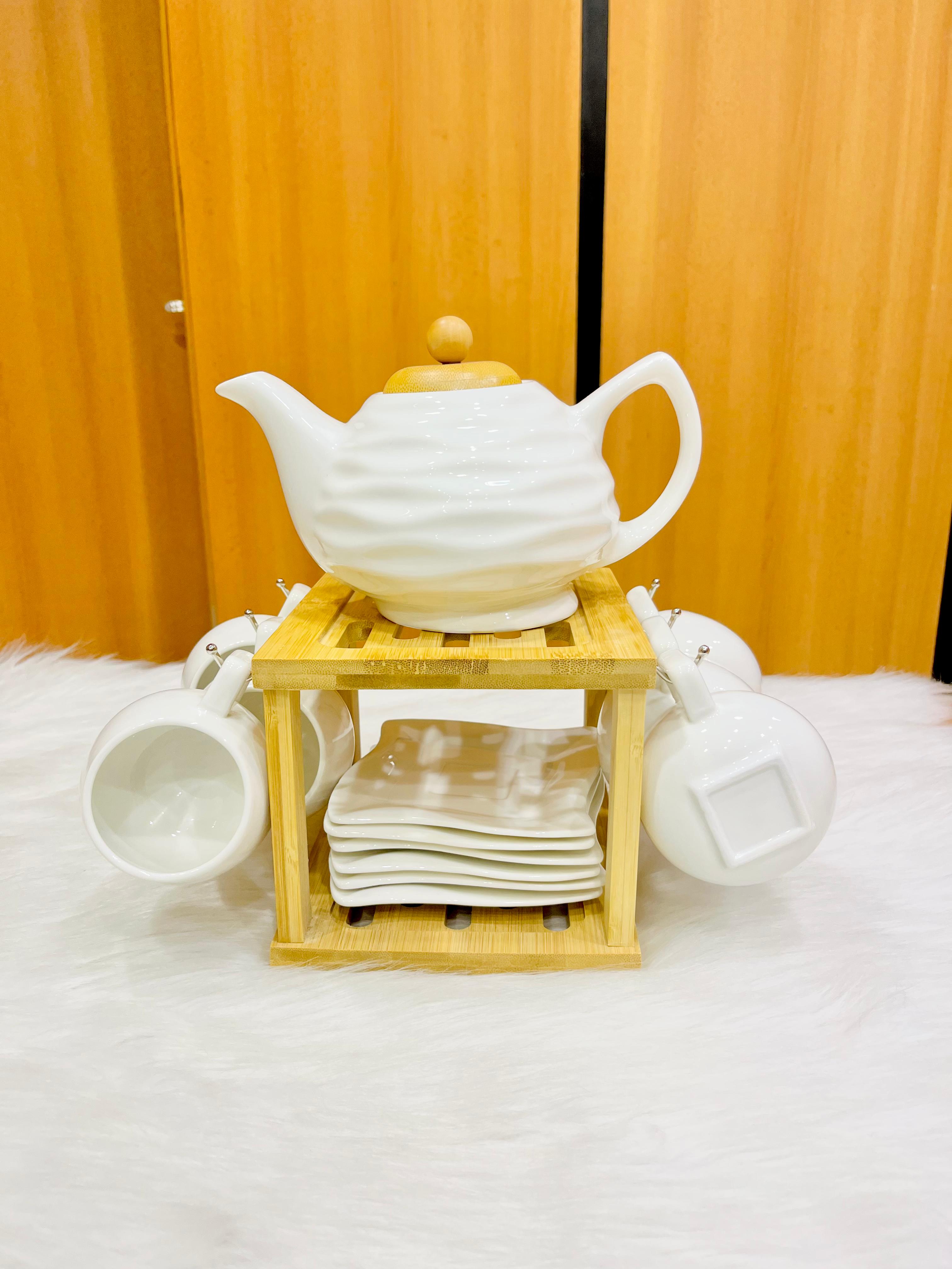Porcelain tea set consisting of teapot 6 cups with saucers and elegant wooden holder for organized display and serving 
